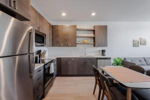 TWO Luxe CozySuites in Downtown Cincinnati في سينسيناتي: مطبخ مع طاولة خشبية ومطبخ مع غرفة طعام +41 صورة