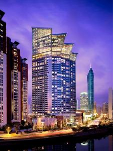a tall building with lights on it in a city at Grand Hyatt Shenzhen in Shenzhen