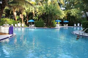 a large swimming pool with chairs and umbrellas at Paradise Point by AvantStay Golf Course Living in Stock Island