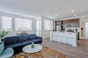 a living room with a blue couch and a kitchen at Cozysuites l Luxe 2BR in Downtown Cincinnati #5 in Cincinnati