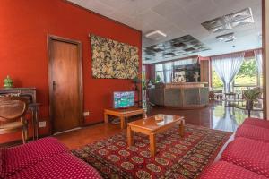salon z czerwonymi ścianami i czerwoną kanapą w obiekcie Hotel Gioiello w Cesenatico