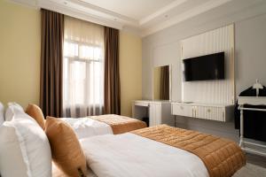a hotel room with two beds and a flat screen tv at Bogishamol Hotel in Samarkand