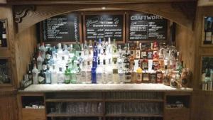 un bar con un montón de botellas de alcohol en The Three Tuns Hotel Wetherspoon, en Thirsk
