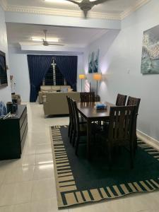 a dining room with a table and chairs and a living room at D Ocean Homestay in Seri Manjung +16 photos