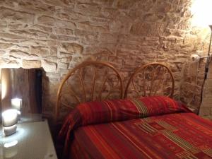 モルフェッタにあるCasa Vacanza Al Torrioneの石壁のベッドルーム1室(ベッド1台付)
