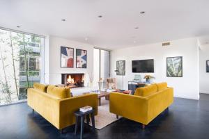 sala de estar con 2 sillas amarillas y chimenea en Balboa I by AvantStay - Stylish Condo Balboa Park Adjacent w Views, en San Diego