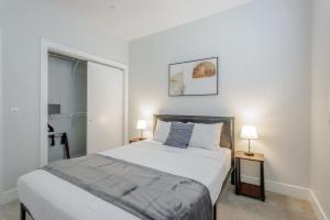 a bedroom with a bed and two lamps and a window at Cozysuites l Luxe 2BR in Downtown Cincinnati #4 in Cincinnati