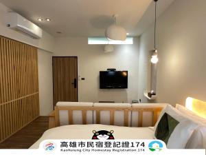 a room with a bed and a tv on the wall at Green Inn Kaohsiung in Kaohsiung