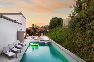 a swimming pool with chairs and a hill at Villa Valencia by AvantStay Entertainers Dream w Outdoor Kitchen Spa Views in San Diego