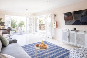 a living room with a couch and a table at Villa Valencia by AvantStay Entertainers Dream w Outdoor Kitchen Spa Views in San Diego