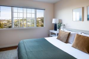 a bedroom with a large bed with two windows at Villa Valencia by AvantStay Entertainers Dream w Outdoor Kitchen Spa Views in San Diego +65 photos