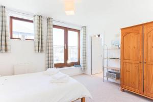 a bedroom with a bed and a large window at Tidemill House Apartment in Falmouth