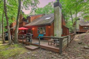 a wooden house with a deck in the woods at Boulder Pointe by AvantStay Deck Forest Views Boulder Lake Club Passes in Lake Harmony
