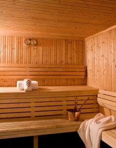 a wooden sauna with two towels and a bucket at Sofitel Al Khobar The Corniche in Al Khobar