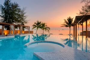 a swimming pool with the ocean in the background at Best Western Plus Carapace Hotel Hua Hin in Hua Hin