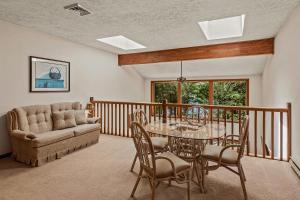 a dining room with a table and a couch at Tranquil Waterside by AvantStay Lakefront Dock Game Room Views in Pocono Summit