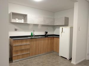 a kitchen with a sink and a refrigerator at Apartamento Panorámico in Santa Cruz de la Sierra