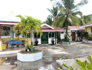 a house with palm trees in the courtyard at La'Liza House Rental in Dapa