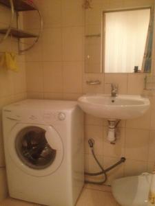 a bathroom with a washing machine and a sink at Apartment Na Gazone in Velikiy Novgorod