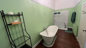 a green bathroom with a toilet and a sink at KIRK - Gorgeous church in the heart of Fife converted into a warm home in Milton of Balgonie +15 photos