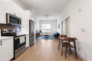 a kitchen with white walls and a table with chairs at Stunning Nulu 1BR CozySuites 07 in Louisville +27 photos