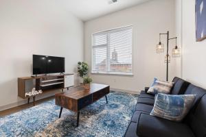 a living room with a couch and a tv at Stunning Nulu 1BR CozySuites 07 in Louisville