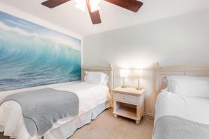 a bedroom with two beds and a painting of the ocean at Eagles Watch by AvantStay Large Deck w Views in Coupeville