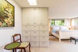 a bedroom with a bed and a table and a chair at Private Beach Access Water Views Sleeps 18 Historic 6BDR Farmhouse w Deck in Clinton