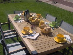 a wooden table with a basket of food on it at Chambre Jonquille - 3 Pers, Nature et Confort - FR-1-589-730 in Moyenmoutier