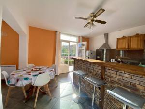eine Küche mit einem Tisch mit Stühlen und einem Deckenventilator in der Unterkunft Appartement T3 rénové avec WIFI, proche des Thermes de Cambo-les-Bains - FR-1-495-145 in Cambo-les-Bains