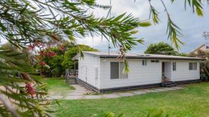 a white cottage in a yard at The Holiday Shack at Flinders in Flinders