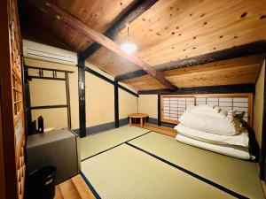 Pokój z łóżkiem w pokoju z drewnianym sufitem w obiekcie Nagomi-Ryokan Yuu w mieście Kioto