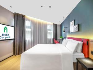 a bedroom with a large white bed and a couch at Campanile Nanjing South Station Daming Road in Nanjing +37 photos