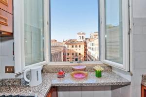 ローマにあるPantheon Family Romantic Suiteの窓から市街の景色を望むキッチンカウンター