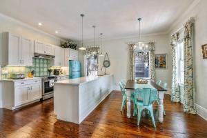 a kitchen with white cabinets and a table and chairs at Lighthouse Villa by AvantStay Walk to Southernmost Point w Private Pool Patio Month Long Stays in Key West