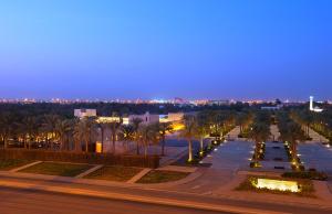 a city street with palm trees at night at All Seasons Hotel Al Ain - Previously City Seasons in Al Ain