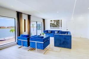 a living room with blue couches and a large window at Club House 305 w PRIVATE NIGHTCLUB, Cinema, Game Room, Gym & Pool in Miami