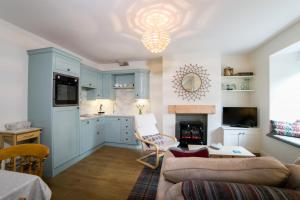 a kitchen with blue cabinets and a living room with a couch at Milburn Cottage in Bellingham