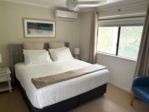a bedroom with a large bed and a window at Tropical Retreat in 2 Bedroom Townhouse in Noosaville +25 photos