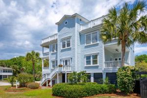 a blue house with a palm tree in front of it at 3800 Cameron Boulevard AvantStay Pool Ocean Views Deck in Isle of Palms
