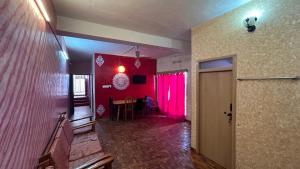 Habitación con pared roja y comedor. en Cloudy Vista Kodai, en Kodaikanal