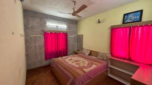 a bedroom with red curtains and a bed in a room at Cloudy Vista Kodai in Kodaikānāl