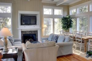 a living room with a couch and a fireplace at 9 24th Avenue by AvantStay Walk to Beach Pool Rooftop Deck in Isle of Palms
