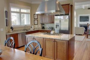 a kitchen with a large island with a stove top at 9 24th Avenue by AvantStay Walk to Beach Pool Rooftop Deck in Isle of Palms