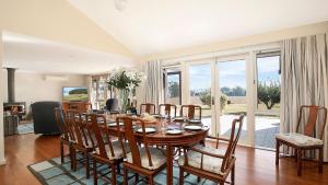 a dining room with a wooden table and chairs at Warrington Park in Berrima