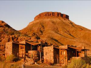 an old building in front of a mountain at Mount Canyon Guest Farm in Keetmanshoop