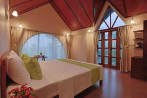 une chambre avec un grand lit et une grande fenêtre dans l'établissement Sundara Retreat, à Hòa Bình