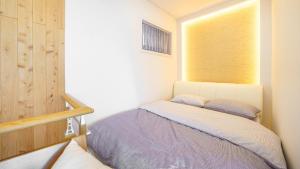 a small bedroom with a bed and a window at Pohang Playbeach Poolvilla in Pohang +1 photo