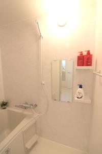 a white bathroom with a mirror and a sink at Shin Osaka Grand Heights SG51 in Osaka +18 photos