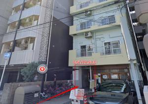 an apartment building with a car parked in front of it at Shin Osaka Grand Heights SG51 in Osaka